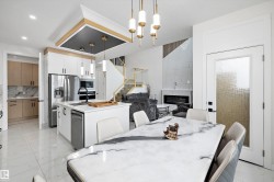 Open concept living area featuring a kitchen island with sink, stainless steel appliances, and wood-finish flooring - 