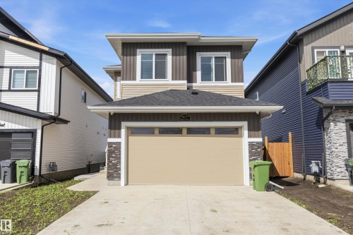 Contemporary two-story exterior featuring a single-car garage, concrete driveway, and a combination of vertical and horizontal siding - 403 Pine Point, Leduc, AB 