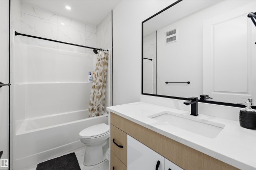Bathroom featuring a rectangular undermount sink, quartz countertop, and black fixtures - 403 Pine Point, Leduc, AB 