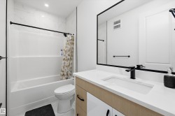 Bathroom featuring a rectangular undermount sink, quartz countertop, and black fixtures - 