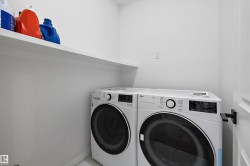 Dedicated laundry space featuring a white built-in shelf and light-colored walls - 