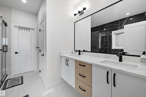 Double vanity with integrated sinks, quartz countertop, and matte black fixtures - 403 Pine Point, Leduc, AB 