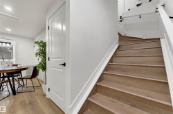 Staircase featuring wood-finish treads and white risers with a contrasting white handrail - 