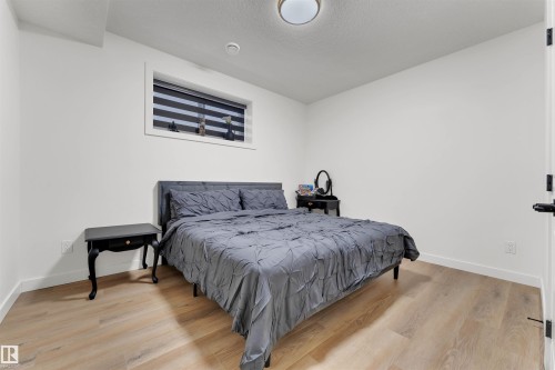 Room featuring wood-finish flooring, white baseboards, and a window with horizontal blinds - 403 Pine Point, Leduc, AB 
