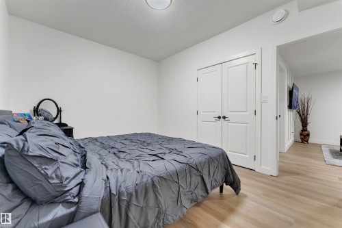 Bedroom featuring light wood-finish flooring, white walls, and a ceiling-mounted light fixture - 403 Pine Point, Leduc, AB 