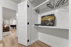 Integrated closet storage featuring white shelving and a hanging rod - 