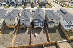 Newly constructed residence with a dark gray shingle roof and a light blue siding exterior - 