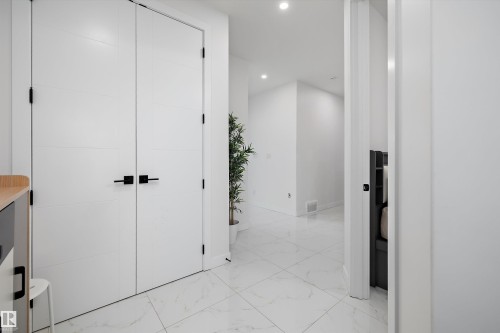 White paneled double doors with matte black hardware - 403 Pine Point, Leduc, AB 