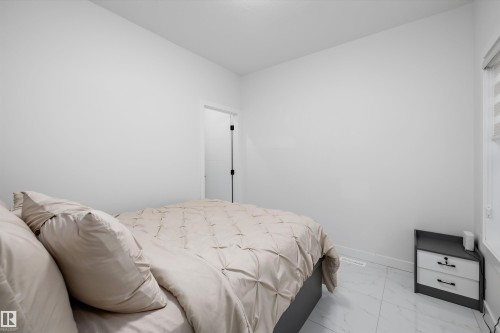 Bright room featuring white walls, white tile flooring, a window with horizontal blinds, and a white baseboard - 403 Pine Point, Leduc, AB 