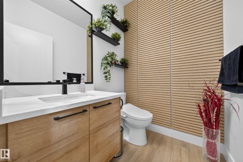 Contemporary bathroom featuring a wood-finish vanity with a white countertop and rectangular undermount sink - 626 Astoria Way, Devon, AB 