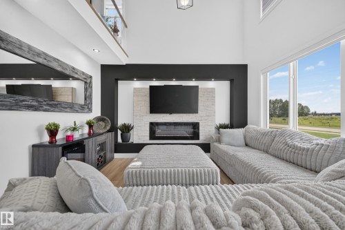 Living area featuring a two-story ceiling and a large picture window - 626 Astoria Way, Devon, AB 