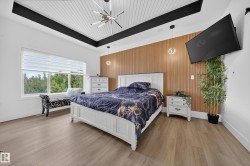 Vaulted ceiling with white paneling and a modern linear chandelier - 
