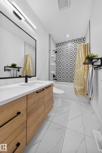 Contemporary bathroom featuring a wood-finish vanity with a white countertop and rectangular sink - 626 Astoria Way, Devon, AB 