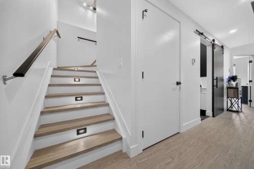 Staircase featuring wood-finish treads, recessed step lighting, and a black handrail - 626 Astoria Way, Devon, AB 