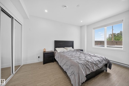 Bedroom featuring light wood-finish flooring, recessed lighting, and a large window with white trim - 626 Astoria Way, Devon, AB 