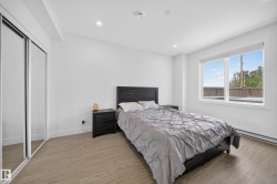 Bedroom featuring light wood-finish flooring, recessed lighting, and a large window with white trim - 