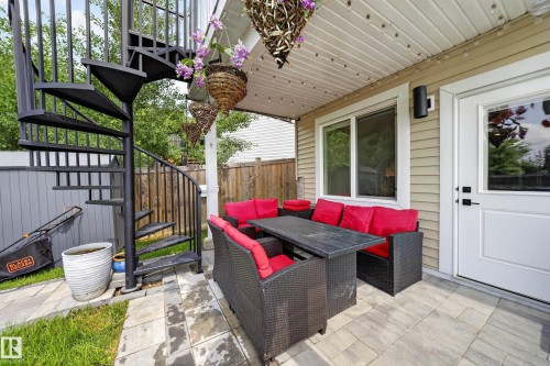 Covered patio featuring a black spiral staircase, paved patio flooring, a window, and an exterior door - 626 Astoria Way, Devon, AB 