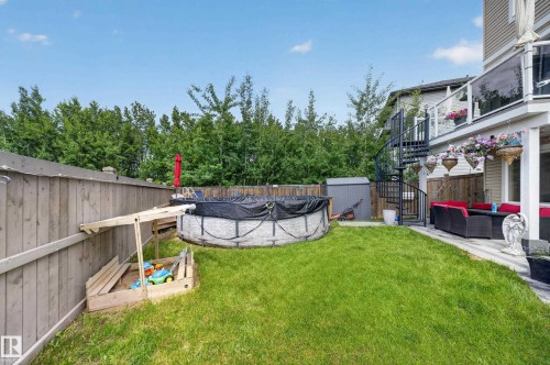 Expansive backyard featuring a manicured lawn, a full wooden fence, and mature trees providing privacy - 626 Astoria Way, Devon, AB 