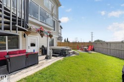 Expansive outdoor space featuring a manicured lawn, a paved patio area, and a built-in hot tub - 