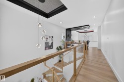 Modern staircase featuring light wood treads and glass railings with wood-finish handrails - 