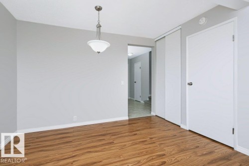 Room featuring wood-finish flooring, light gray wall paint, and white baseboards - 24 14511 52 Street, Edmonton, AB 