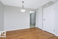 Room featuring wood-finish flooring, light gray wall paint, and white baseboards - 