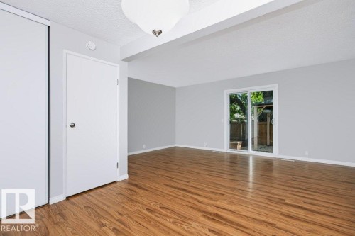 Open-concept living space featuring wood-finish flooring, light grey walls, and a white ceiling - 24 14511 52 Street, Edmonton, AB 
