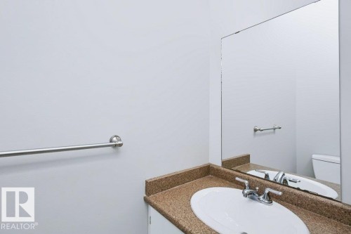 Bathroom vanity featuring an oval undermount sink, dual-handle chrome faucet, and a speckled countertop - 24 14511 52 Street, Edmonton, AB 