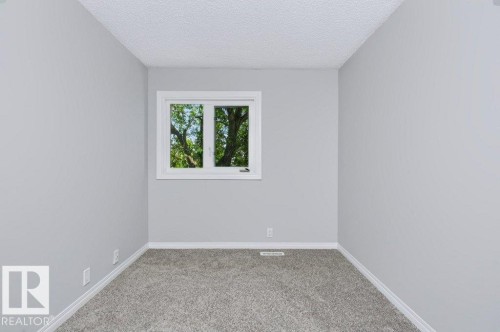 Bright room with gray textured carpeting, light gray painted walls, a white-framed window, and white baseboards - 24 14511 52 Street, Edmonton, AB 
