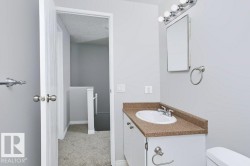 Bathroom vanity featuring a white oval sink, chrome faucet, and a speckled countertop - 
