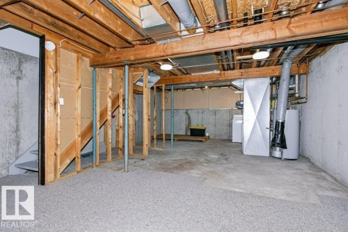 Unfinished basement featuring exposed wood joists, concrete foundation walls, and a partial subfloor - 24 14511 52 Street, Edmonton, AB 