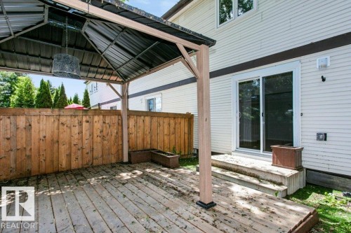 Expansive outdoor deck featuring a covered gazebo structure, a privacy fence, and direct access to the interior via sliding glass doors - 24 14511 52 Street, Edmonton, AB 