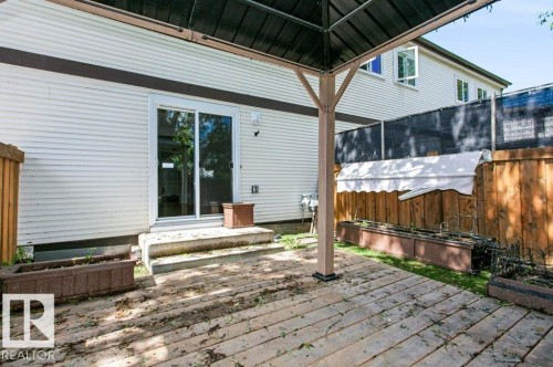 Outdoor wood-finish decking with a dark metal gazebo frame - 24 14511 52 Street, Edmonton, AB 