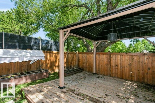 Outdoor wood deck featuring a covered gazebo structure with a metal roof and a hanging light fixture - 24 14511 52 Street, Edmonton, AB 