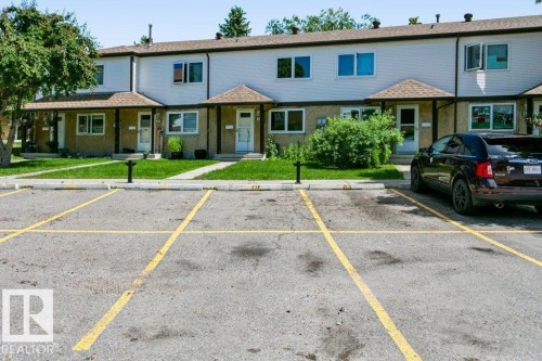 Paved parking area with marked spaces, bordered by a concrete curb - 24 14511 52 Street, Edmonton, AB 