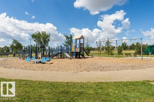 Neighborhood playground featuring multiple slides, swings, and a seesaw - 24 14511 52 Street, Edmonton, AB 