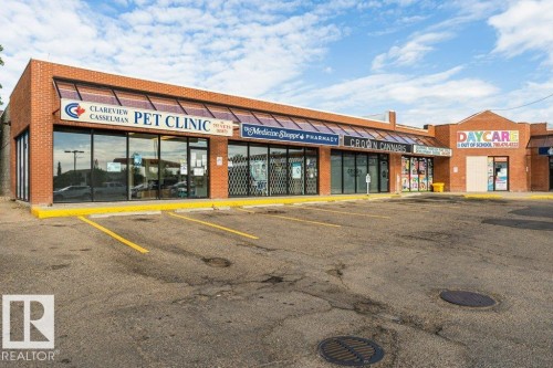 Commercial strip mall building featuring brick facade and a prominent storefront window line - 24 14511 52 Street, Edmonton, AB 