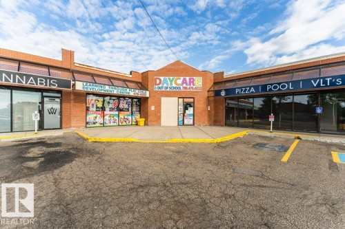 Brick facade commercial building with prominent storefronts, expansive window displays, and dedicated parking - 24 14511 52 Street, Edmonton, AB 