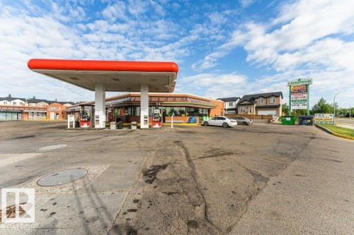 Commercial property featuring a gas station canopy with multiple pumps, an attached convenience store, and a prominent roadside sign - 24 14511 52 Street, Edmonton, AB 