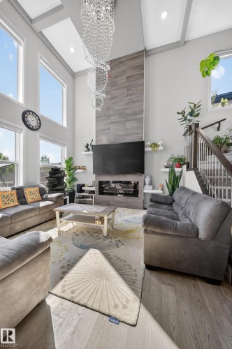 Spacious living area featuring a two-story ceiling with recessed lighting and decorative beams - 1927 18 Street, Edmonton, AB 