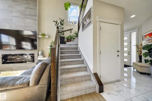 Carpeted staircase with dark wood-finish handrail, leading to an upper level - 1927 18 Street, Edmonton, AB 
