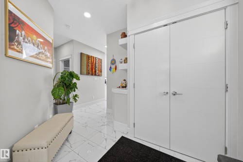 Entryway featuring white tile flooring with gray veining, recessed lighting, and white walls - 1927 18 Street, Edmonton, AB 