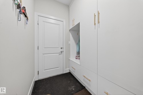 Integrated mudroom-style storage solution with white cabinetry and gold-finish hardware - 1927 18 Street, Edmonton, AB 