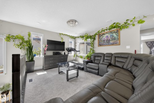 Bright living area featuring a neutral color palette, multiple windows, recessed lighting, and a modern chandelier fixture - 1927 18 Street, Edmonton, AB 