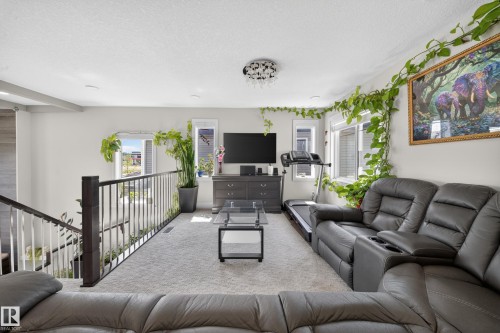 Carpeted upper-level landing with dark wood newel posts and metal spindles - 1927 18 Street, Edmonton, AB 