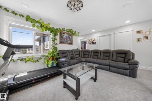 Carpeted living area featuring recessed lighting, a large window, and light gray wall paint - 1927 18 Street, Edmonton, AB 