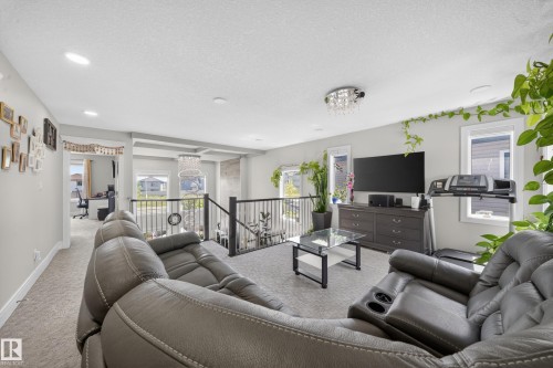 Open-concept upper level featuring neutral carpet flooring, recessed lighting, and a chandelier fixture - 1927 18 Street, Edmonton, AB 
