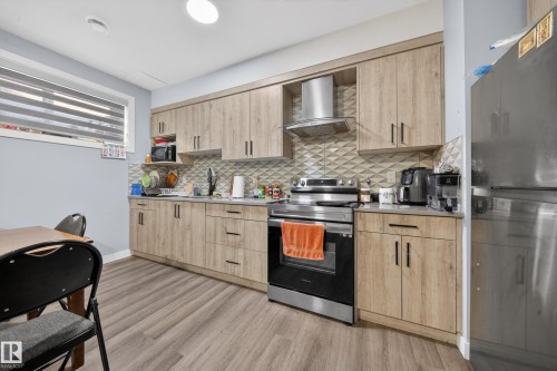 Contemporary kitchen featuring wood-look cabinetry and grey countertops - 1927 18 Street, Edmonton, AB 