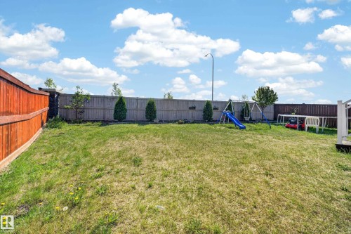 Expansive grassy yard with full perimeter fencing featuring both natural wood and stained wood panels - 1927 18 Street, Edmonton, AB 