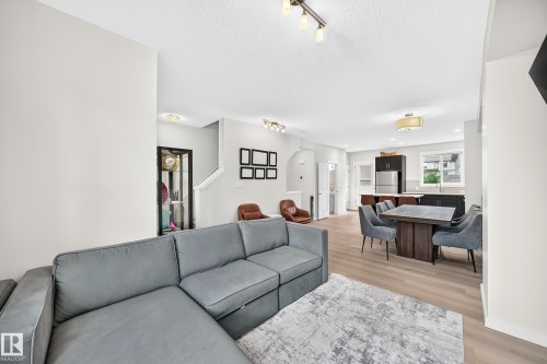 Open-concept living space featuring light wood-finish flooring, recessed lighting, and a modern kitchen with stainless steel appliances - 118 655 Watt Boulevard Sw, Edmonton, AB 
